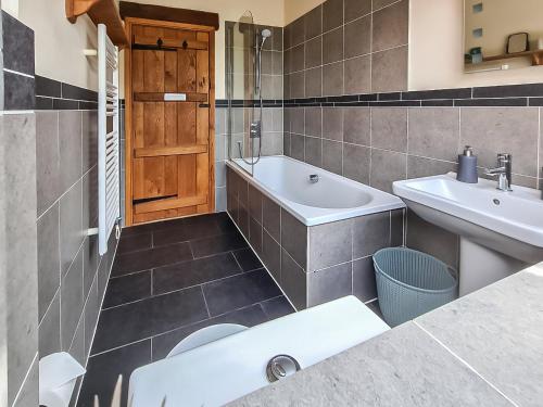 uma casa de banho com uma banheira, um lavatório e um WC. em Bramble Barn em Tortworth