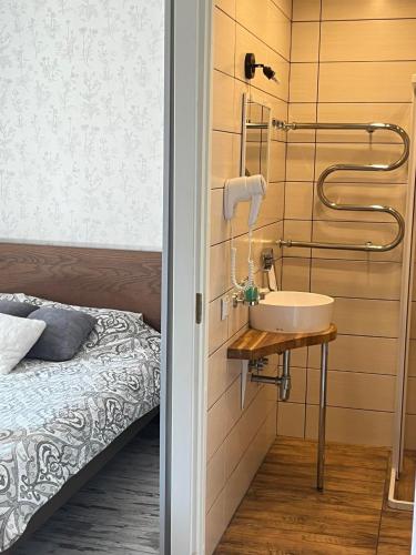 a bathroom with a sink next to a bed at Godart Rooms Guesthouse in Tallinn