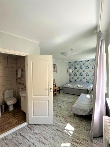 a room with a bathroom with a bed and a toilet at Godart Rooms Guesthouse in Tallinn