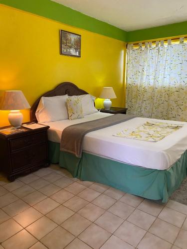 um quarto com uma cama grande e paredes amarelas em kings landing hotel 