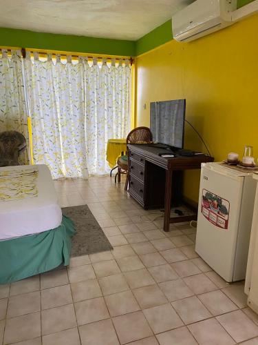 a living room with a desk and a refrigerator at kings landing hotel 