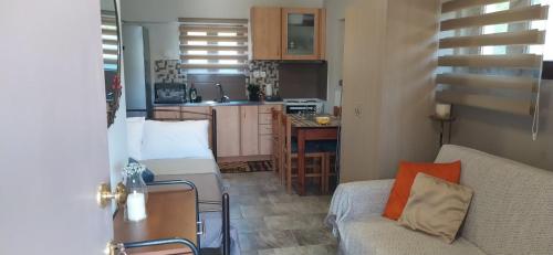 ein Wohnzimmer mit einem Sofa und einer Küche in der Unterkunft ΣΤΟΥΝΤΙΟ ΕΥΑΓΓΕΛΙΑ in Nafpaktos