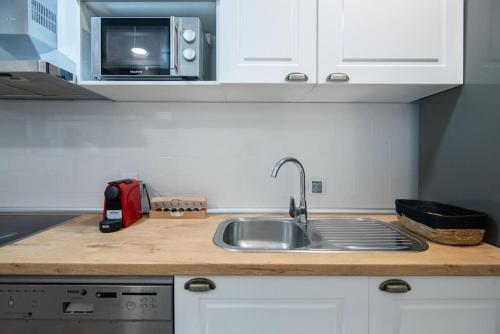 a kitchen counter with a sink and a microwave at +25Y ONLY, Family flat near the beach in Barcelona