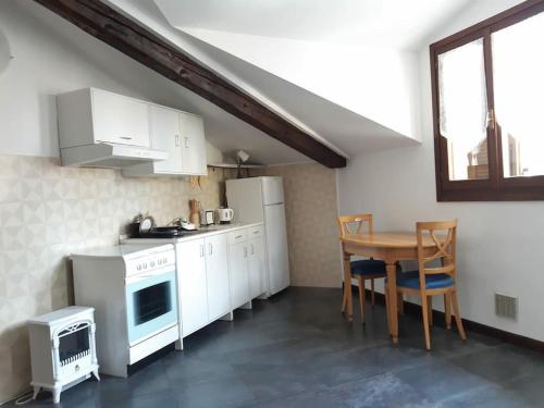 a kitchen with white cabinets and a table with chairs at Monolocale piano alto luminoso pochi minuti metro rossa Milano in Milan