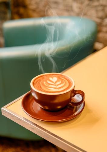 a cup of coffee sitting on a table at Royal Almashaer in Makkah