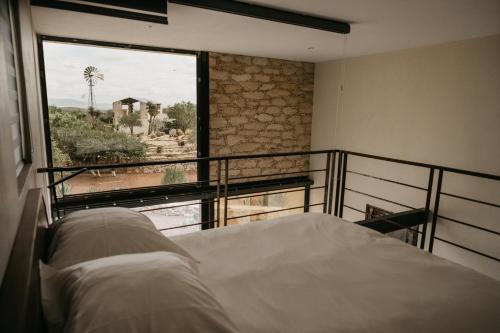 um quarto com uma cama e uma grande janela em Mineral del Cielo em Mineral de Pozos