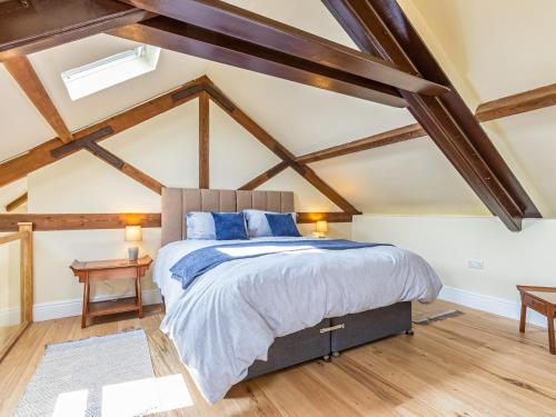 a bedroom with a king sized bed and wooden beams at The Old Stable in Dursley