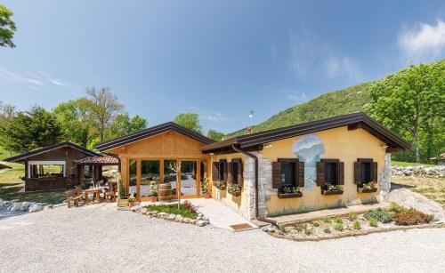 a house with a building with a mountain in the background at Agriturismo Fattoria Carolina - Friuli Venezia Giulia - Val d'Arzino in Vito dʼAsio