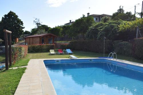 a swimming pool in a yard with a house at Refugio D Alecrim in Paredes