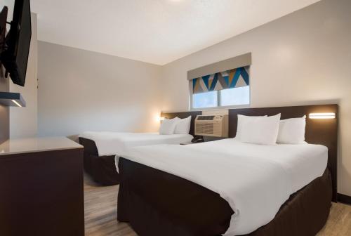 Кровать или кровати в номере Suburban Studios Biloxi North Area