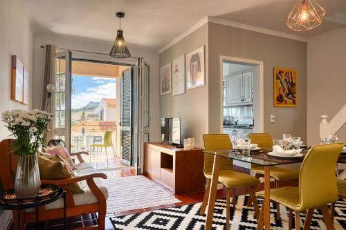 a dining room and living room with a table and chairs at Porto Santo Pip House, a Home in Madeira in Porto Santo