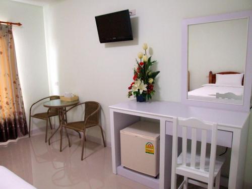 a room with a table and a mirror and a bed at Ruan Rim Nam in Roi Et