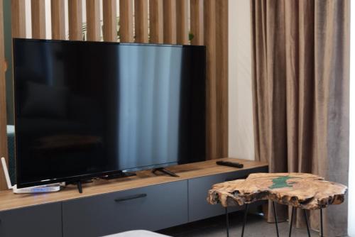 a large flat screen tv sitting on top of a cabinet at Voyage Apartment in Himare