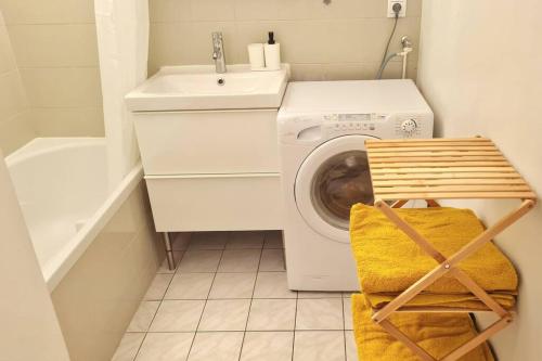 een wasruimte met een wasmachine en een wastafel bij Appart Cosy & Spacieux-Métro7 Louis-Aragon+Parking in Vitry-sur-Seine