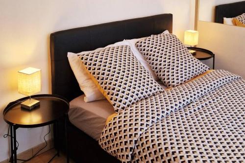 a bed with a checkered blanket and a side table at Appart Cosy & Spacieux-Métro7 Louis-Aragon+Parking in Vitry-sur-Seine