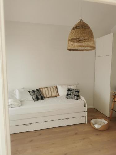 - un canapé blanc avec des oreillers dans l'établissement Villa des Oyats, à Vieux-Boucau-les-Bains