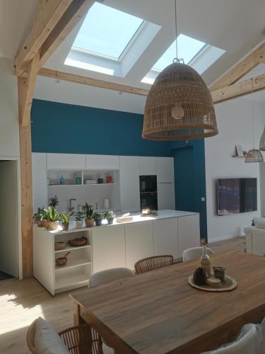 Il comprend une cuisine avec une table à manger et une lucarne. dans l'établissement Villa des Oyats, à Vieux-Boucau-les-Bains