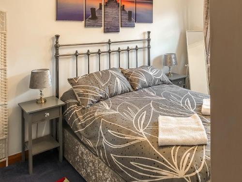 una camera con un letto e due comodini con lampade di Longtye Cottage a Swalecliffe