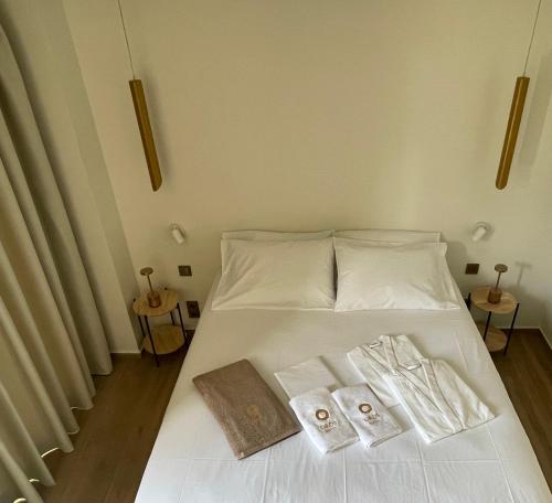 Oikos Sani Suites في ساني بيتش: سرير ابيض وفوطه منشفتين