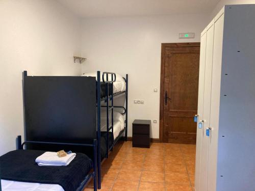a room with two bunk beds and a door at Albergue O Beque in Moaña