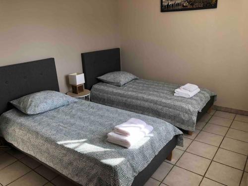 two beds sitting next to each other in a room at Villa Bonheur secteur Blagnac 9 pers Netflix Wifi in Mondonville