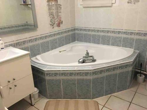 een badkamer met een ligbad en een wastafel bij Villa Bonheur secteur Blagnac 9 pers Netflix Wifi in Mondonville
