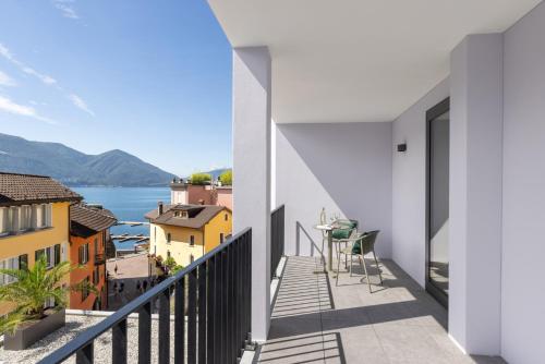 アスコナにあるLiving Ascona Boutique Hotel - Smart Hotelの水辺と建物の景色を望むバルコニー