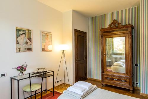 una camera con letto, cassettiera e specchio di Villa la Ginestra - Charming Country Rooms a Subbiano