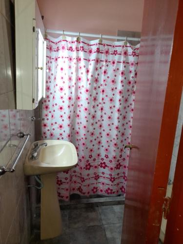 a bathroom with a shower curtain with red hearts at Valentino Apart I in Jesús María