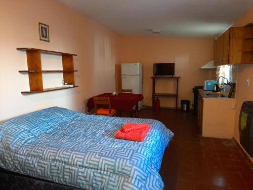 a bedroom with a bed and a kitchen with a refrigerator at Valentino Apart I in Jesús María