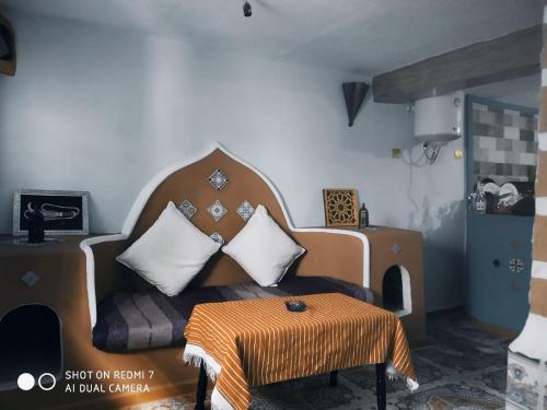 ein Wohnzimmer mit einem Sofa und einem Tisch in der Unterkunft شفشاون in Aït Saïd