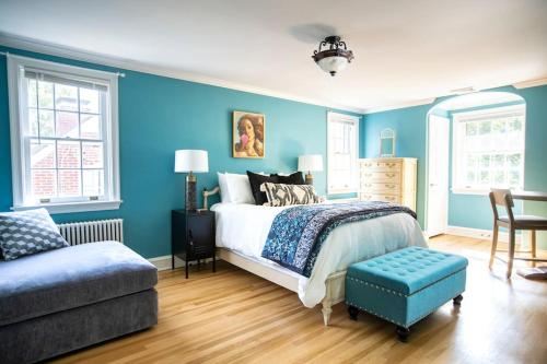 1 dormitorio con paredes azules, 1 cama y 1 silla en Beautiful fully-furnished Colonial in Millersville, en Millersville