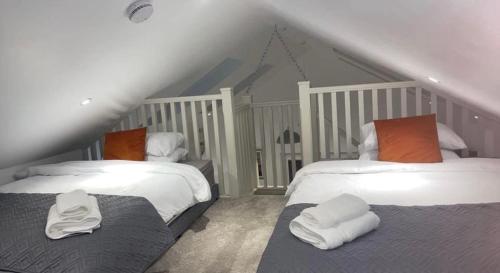 a bedroom with two beds with white pillows at Sèid Bò - Sleeps 6 - NEW Private 6 Person HotTub Available in Burnfoot