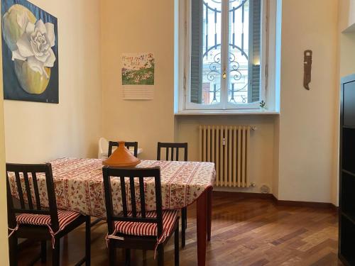 a dining room with a table and chairs and a window at Casa vela in Turin