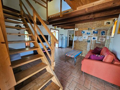 sala de estar con escalera y sofá rojo en "La casetta" indipendente, con ampio spazio verde, en Fontechiari