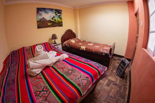 a room with two beds and a towel on the bed at Guest House Sky Lake in Copacabana