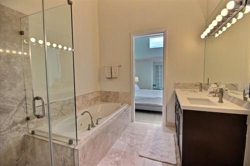 W łazience znajduje się wanna, umywalka i prysznic. w obiekcie 705 Mariners Club w mieście Key Largo
