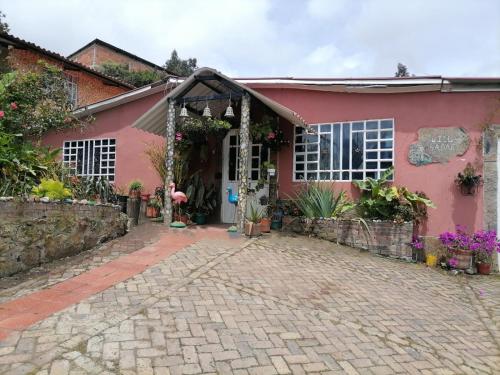 a pink house with a brick driveway at Hospedaje Rural Villa Sadais in Monguí