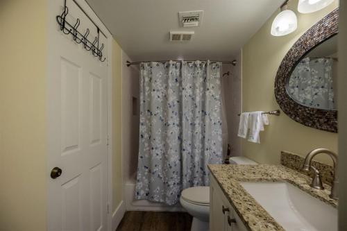 a bathroom with a toilet and a sink and a mirror at 2405 Ocean Pointe in Tavernier