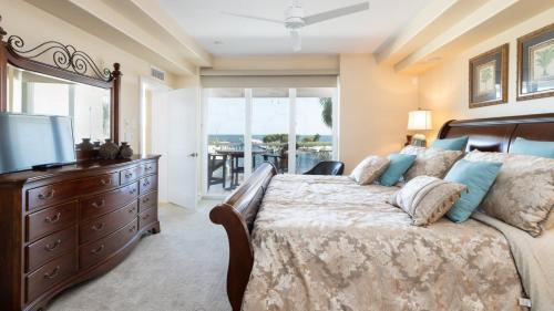 a bedroom with a large bed with a dresser and a television at 122 Mariners Club in Key Largo