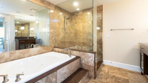 a bathroom with a tub and a glass shower at 122 Mariners Club in Key Largo