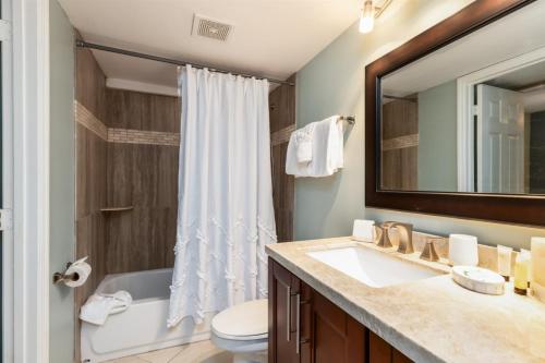 a bathroom with a sink and a toilet and a mirror at 2402 Ocean Pointe in Tavernier
