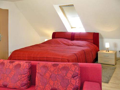 ein Schlafzimmer mit einem roten Bett und einem Sofa in der Unterkunft Ferienwohnungen mit Balkon in Kröslin