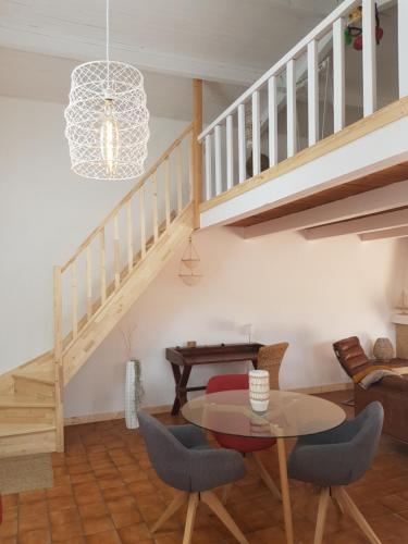 a living room with a table and a staircase at Huitres et mer in Marennes