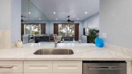 a kitchen with a sink and a living room at 409 Mariners Club in Key Largo