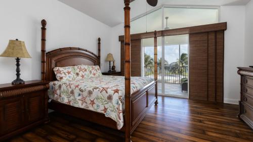 a bedroom with a canopy bed and a balcony at 409 Mariners Club in Key Largo