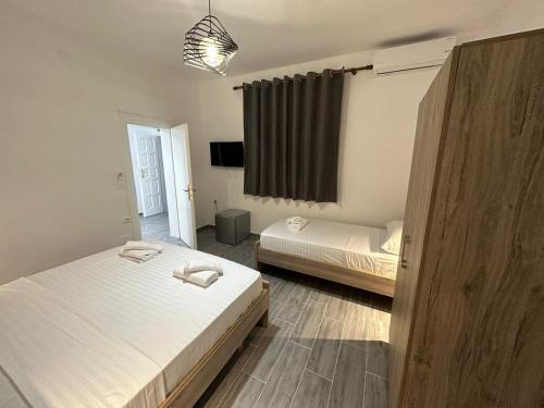 1 dormitorio con 2 camas, TV y ventana en Rus Villa, en Berat