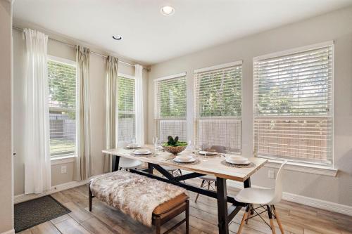 a dining room with a table and chairs and windows at City Getaway Yard Bbq Games Wifi Pets Ok in Houston