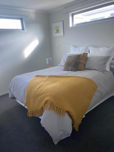 a bedroom with a large bed with a yellow blanket on it at Bunker on Belt in New Plymouth