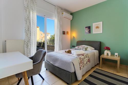 a bedroom with a bed and a desk and a window at Elysian Rose Residence in Rethymno